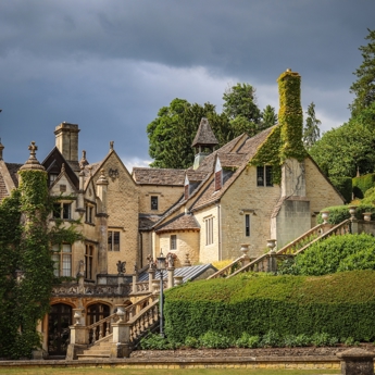 a large country house covered in Ivy with a stone staircase. It is perfect for a wedding venue